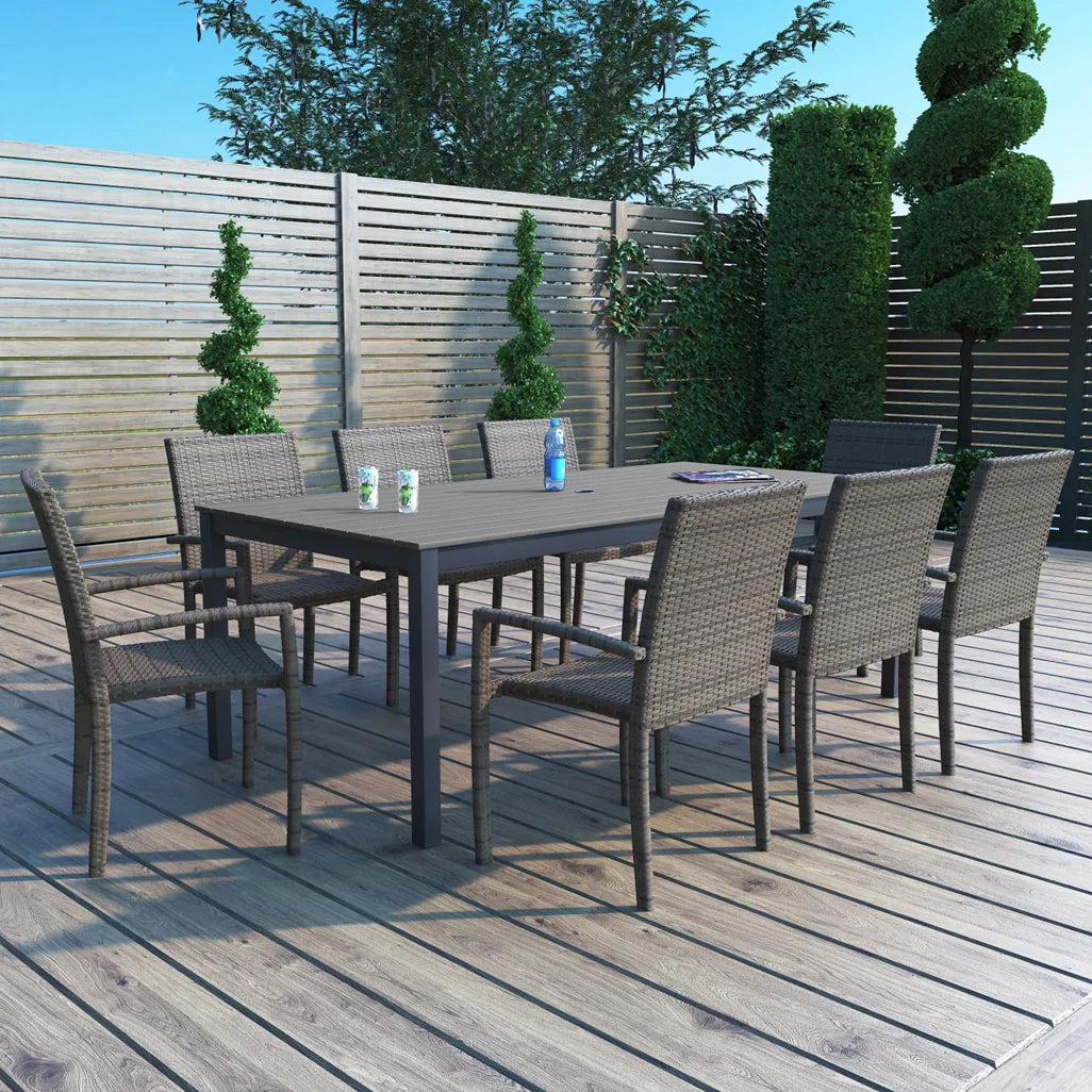 Outdoor wicker dining set on outdoor patio and deck with ornamental topiaries and bushes