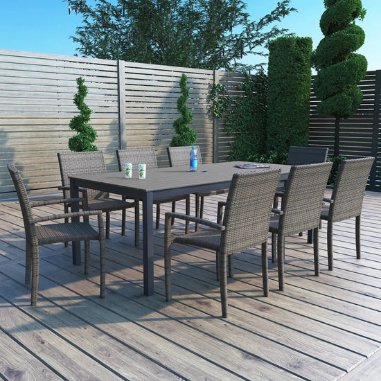 Outdoor wicker dining set on outdoor patio and deck with ornamental topiaries and bushes